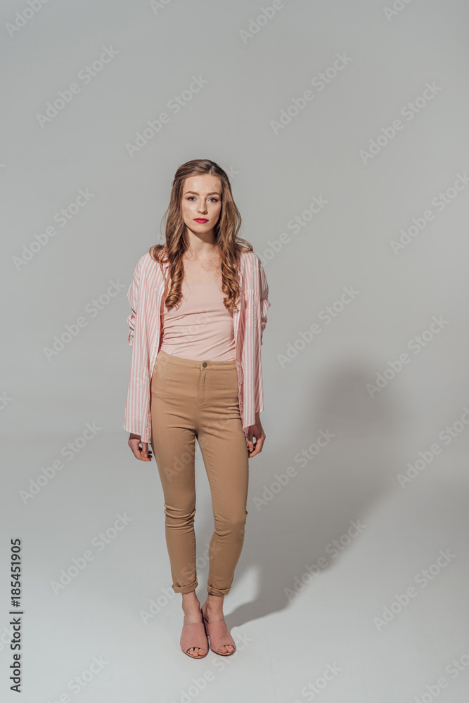 full length view of beautiful young woman in looking at camera isolated on grey full length view of beautiful young woman in looking at camera isolated on grey