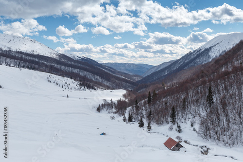A small hut in front of a mountain covered in snow during the Ukrainian winter photo