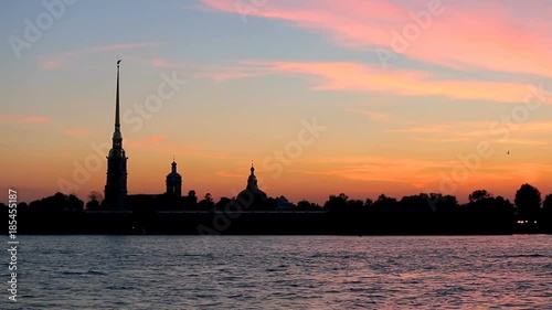 silhouette of Peter and Paul fortress against the backdrop of the setting sun photo