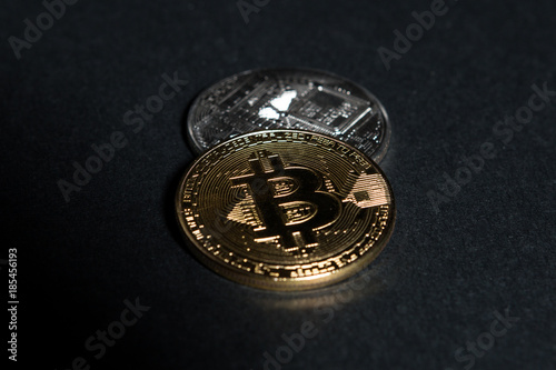 Two coins as bitcoins concept on dark black background