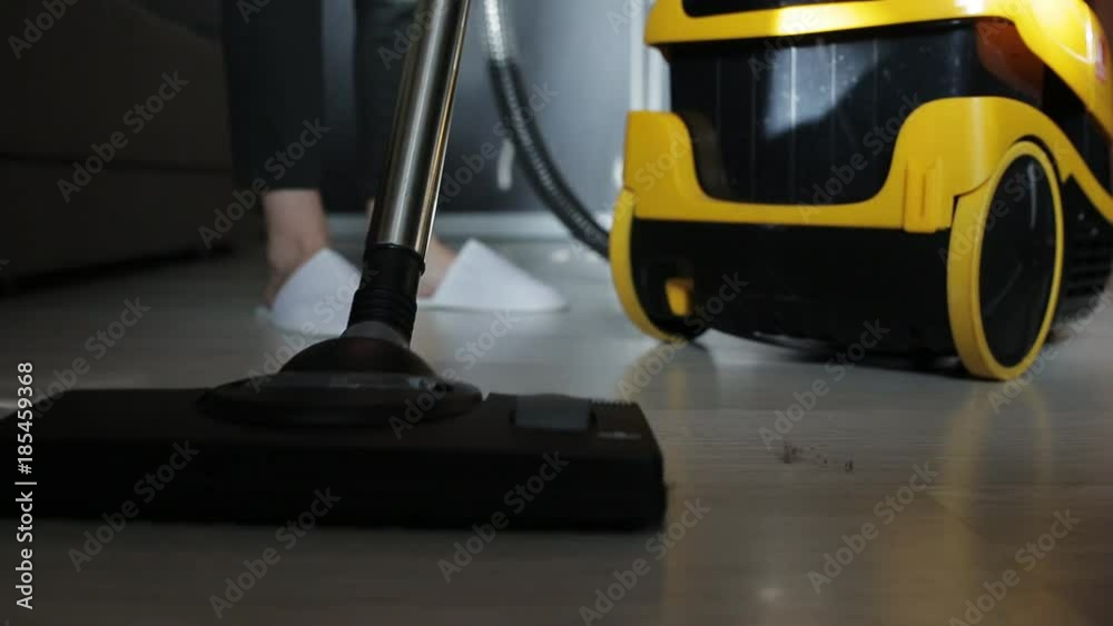 Young attractive housewife vacuuming in the room. Young attractive housewife vacuuming in the room.