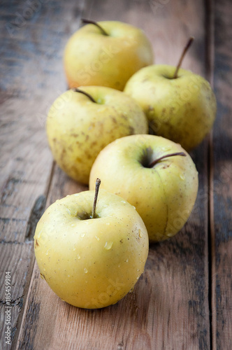 Fresh yellow apples on a wooden background