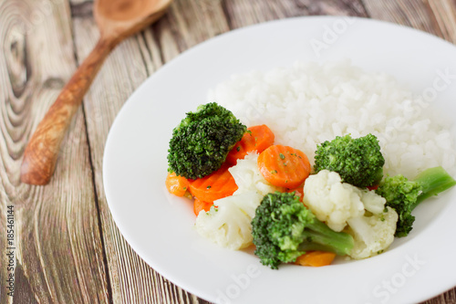Rice and vegetables on a wooden background. broccoli and sliced carrots. healthy diet or vegetarian food. front horizontal view