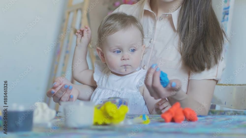 Mother and girl make figures of plasticine and kinetic sand Mother and girl make figures of plasticine and kinetic sand