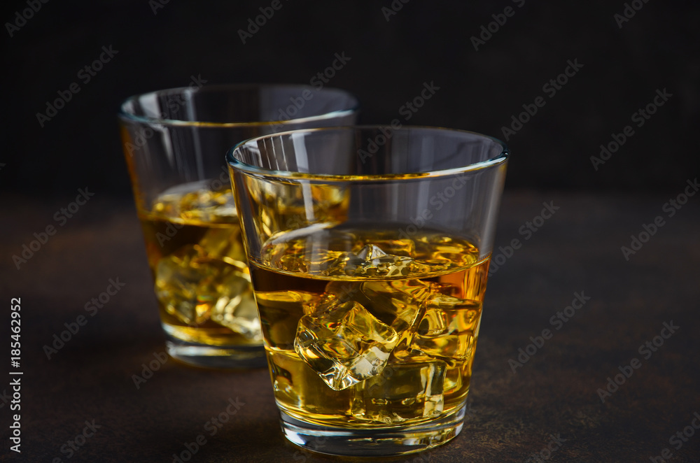 Glass of whiskey with ice on the old rusty background Selective focus Glass of whiskey with ice on the old rusty background Selective focus