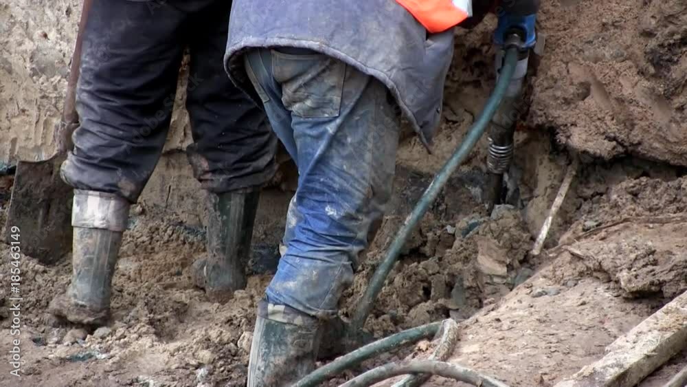 Construction site and workers work as a jackhammer in the ground Construction site and workers work as a jackhammer in the ground