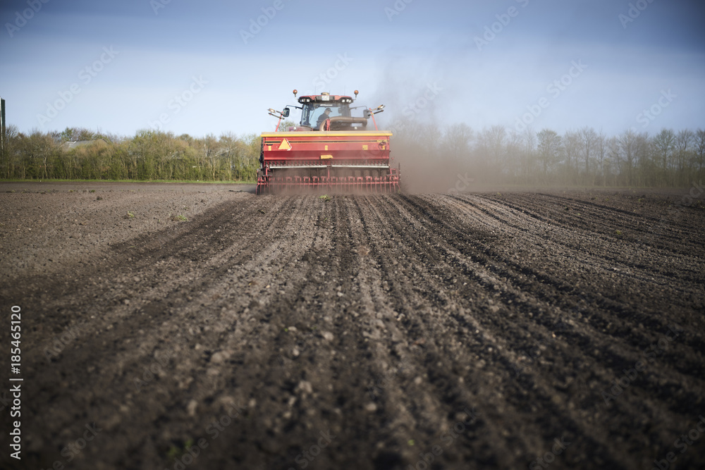 Fototapeta premium Red tractor plow field