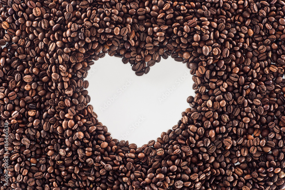 top view of heart made from roasted coffee beans on white top view of heart made from roasted coffee beans on white