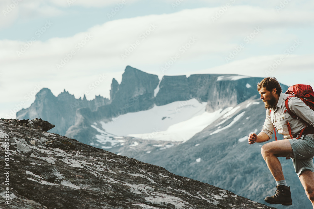 Active Man running in mountains with backpack Norway Travel hiking lifestyle concept active weekend summer vacations skyrunning sport