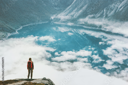Traveling woman above clouds and lake in mountains adventure Lifestyle wanderlust concept vacations outdoor hiking with backpack