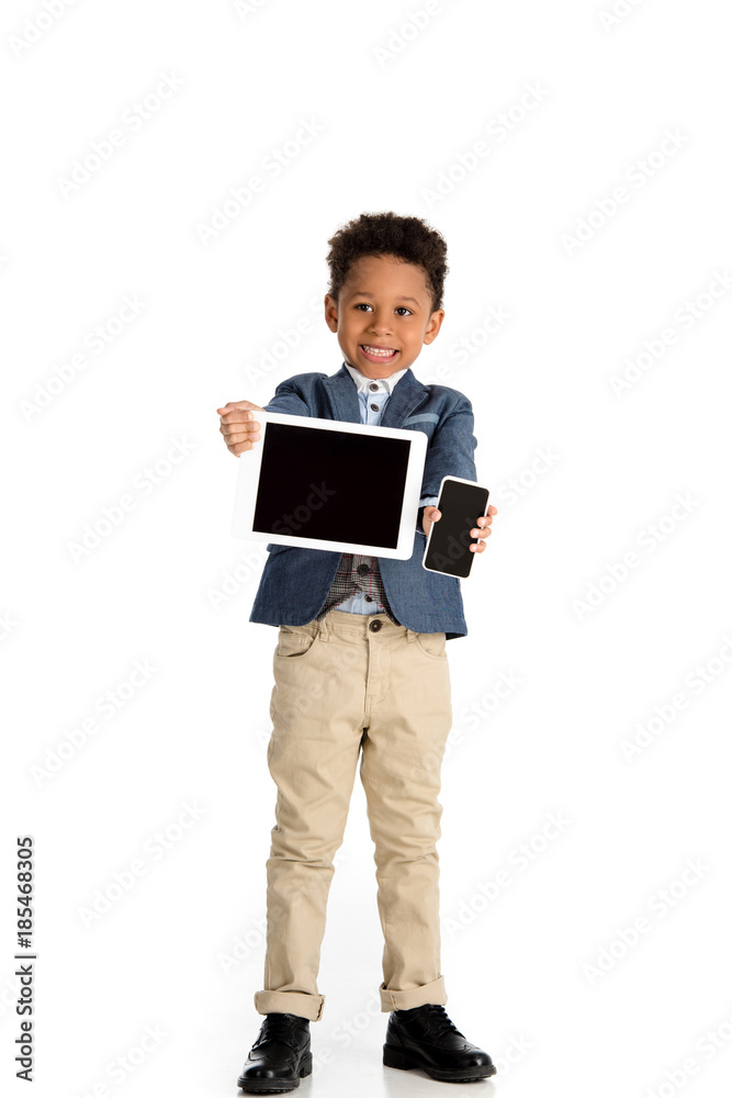 smiling african american kid showing tablet and smartphone on white smiling african american kid showing tablet and smartphone on white