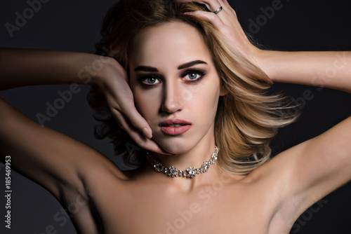 Studio beauty portrait of gorgeous blonde woman on black background