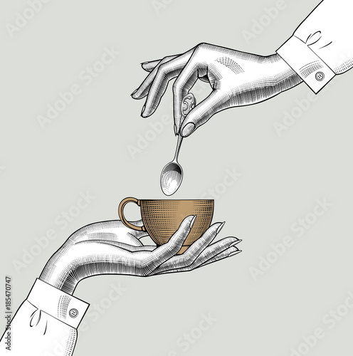 Pair of female hands with a coffee cup and spoon