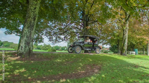 Slow drive through the magnificent tree-lined road in a outstanding first wooden car that was constructed by Henry Ford from USA.