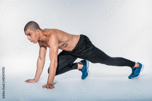 african american sportsman stretching legs