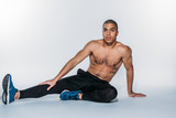 torso african american sportsman sitting on floor and stretching