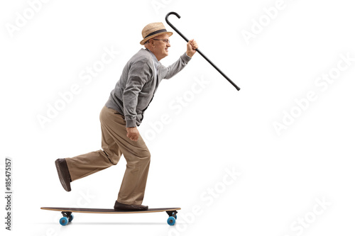 Mature man with a cane riding a longboard
