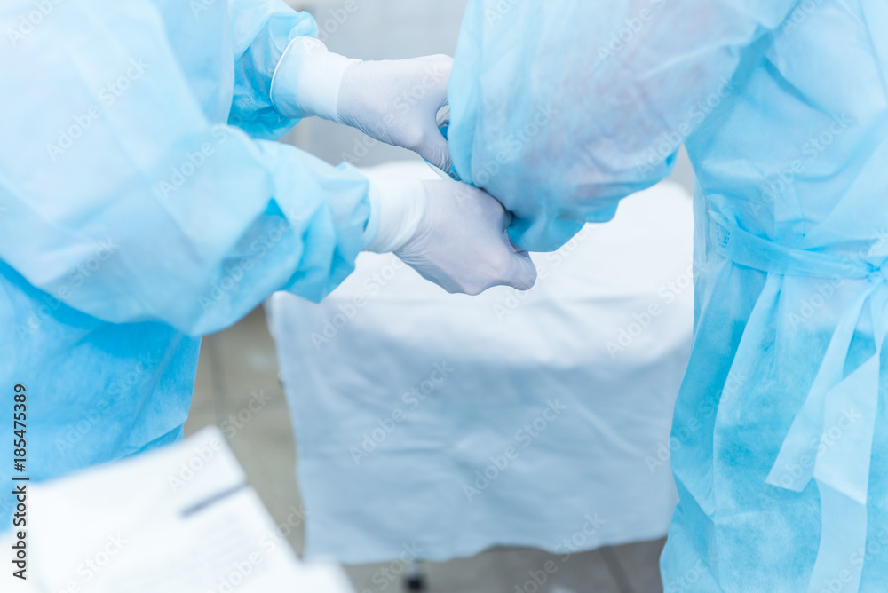 Fototapeta premium the hands of surgeons physicians doing surgery to the patient in the clinic, the concept of photo medicine, professional doctors, anesthesia