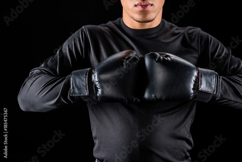 Cropped shot of African American boxer in black gloves isolated on black