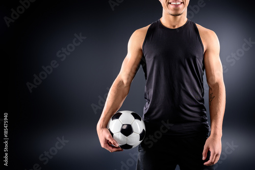 cropped shot of african american soccer player with ball on black © LIGHTFIELD STUDIOS