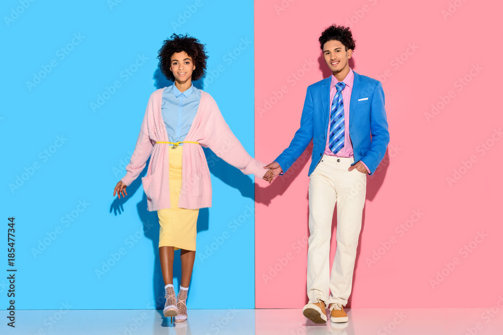 Naklejka premium happey couple holding hands on pink and blue background