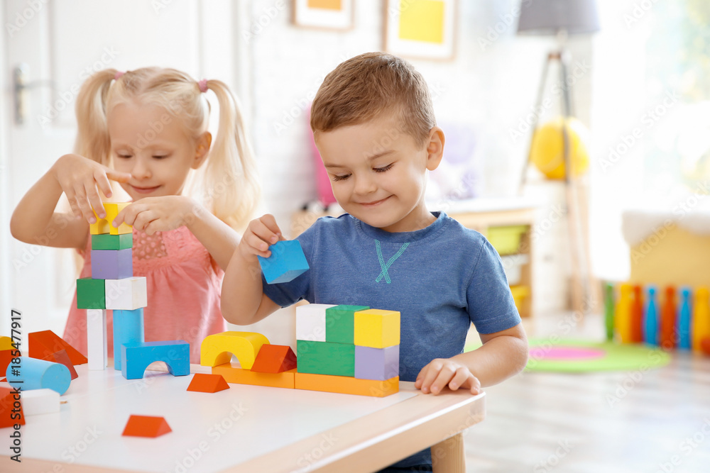 Fototapeta premium Cute little children playing with blocks at home