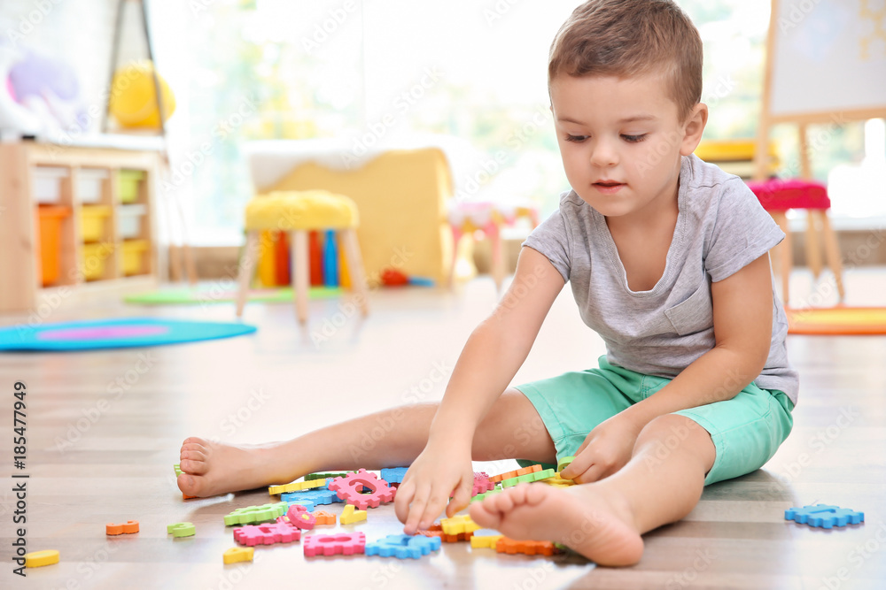 Cute little boy playing with math puzzle at home Cute little boy playing with math puzzle at home