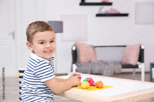 Cute little boy modeling from playdough at home
