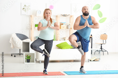 Overweight couple doing exe...