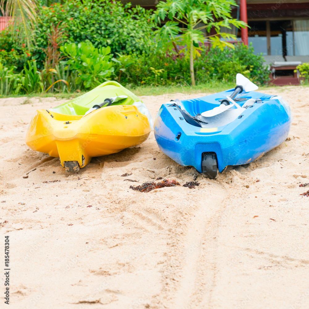 Two bright empty canoe at sand beach Two bright empty canoe at sand beach