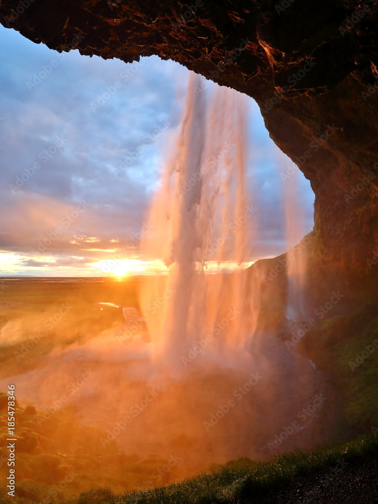 Fototapeta premium zachód słońca za wodospadem w islandii, wodospad Seljalandsfoss