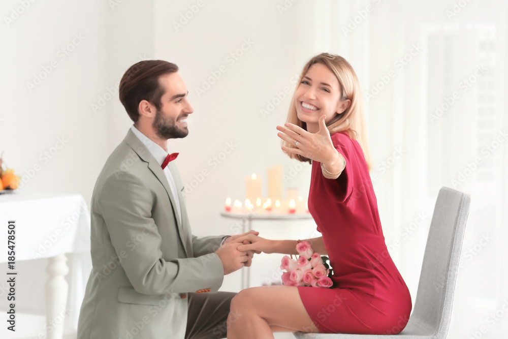 Young man and his happy fiancee showing engagement ring in restaurant Young man and his happy fiancee showing engagement ring in restaurant