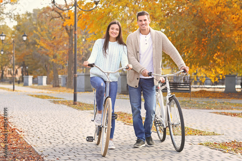 Young couple riding bicycles in park © Africa Studio