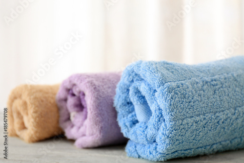 Bath towels on table against light background