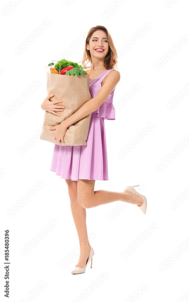 Young woman holding paper bag with groceries on white background Young woman holding paper bag with groceries on white background