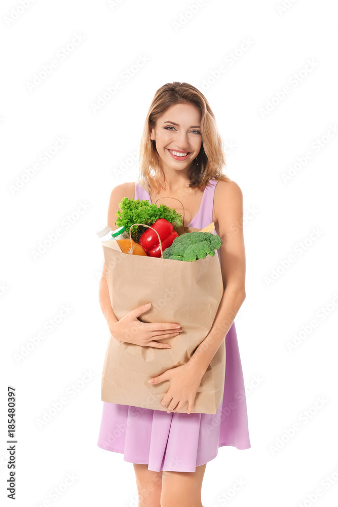 Young woman holding paper bag with groceries on white background Young woman holding paper bag with groceries on white background