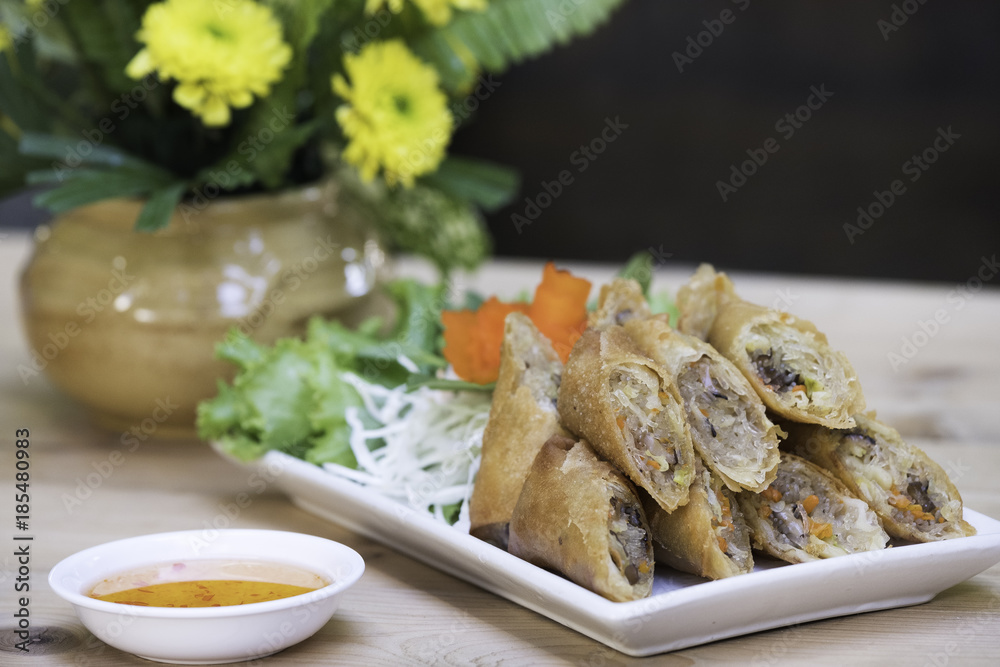 Spring roll on white dish with sweet and spicy in the kitchen / Selective focus image ans