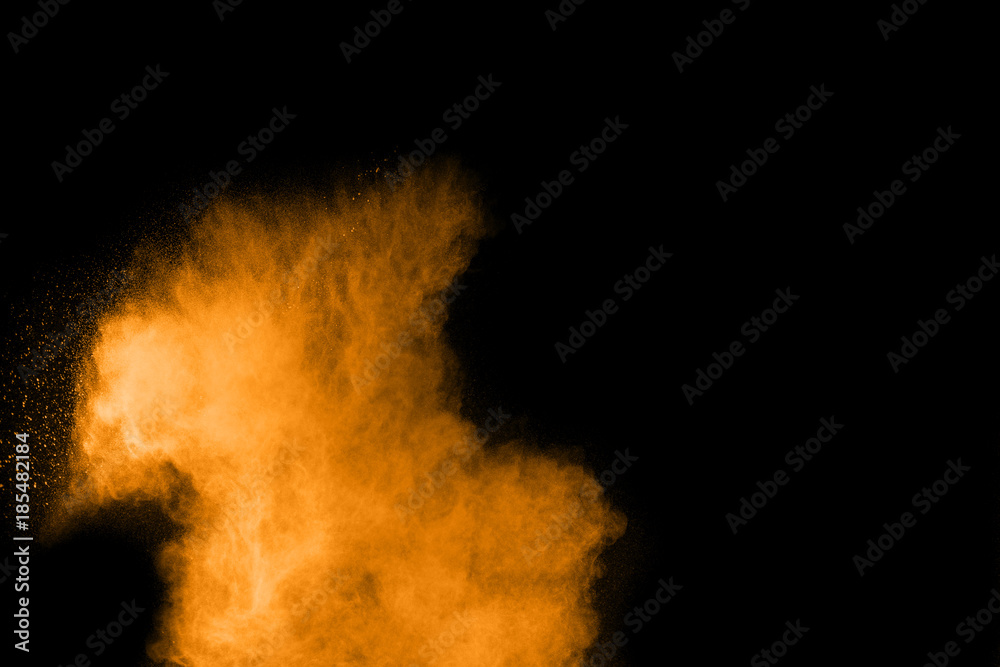 stract orange dust explosion on  black background. abstract orange powder splattered on black background, Freeze motion of orange powder splash.