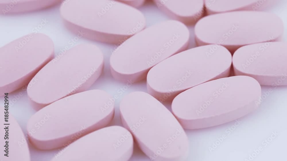 Oval pink tablets on plate Oval pink tablets on plate