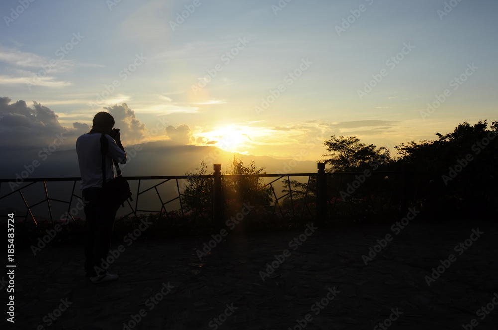 Man taking photo of sunset, north, Thailand.