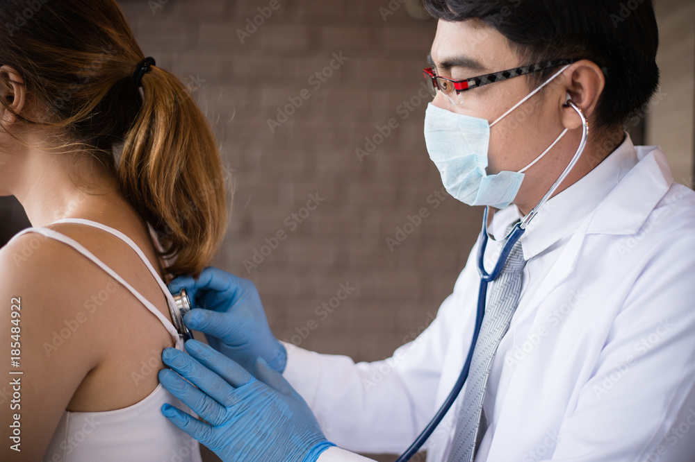 The doctor holding a stethoscope and put it on the woman patient's back at the Hospital. Concept of Healthcare, Medical treatment , examination