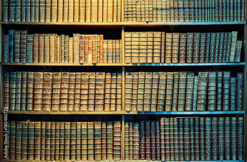 Vintage toned old books on wooden shelves, education concept background.