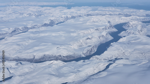 Aerial view of the glaciers, rivers and icebergs on the south coast of Greenland from the window of an airplane from UK to San Francisco