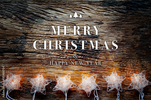 Merry christmas and happy new year text on vintage wooden table with christmas lighting decoration.