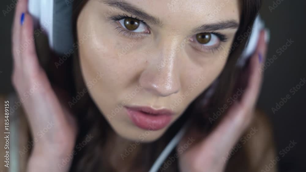 Face of sexy brunette close-up. A young woman in big white headphones is flirting with the camera. eroticly opens his mouth. chubby female lips. 4k Face of sexy brunette close-up. A young woman in big white headphones is flirting with the camera. eroticly opens his mouth. chubby female lips. 4k
