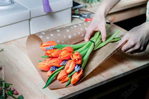 Florist at work: the Assembly of a bouquet of tulips in a wrapper made of paper