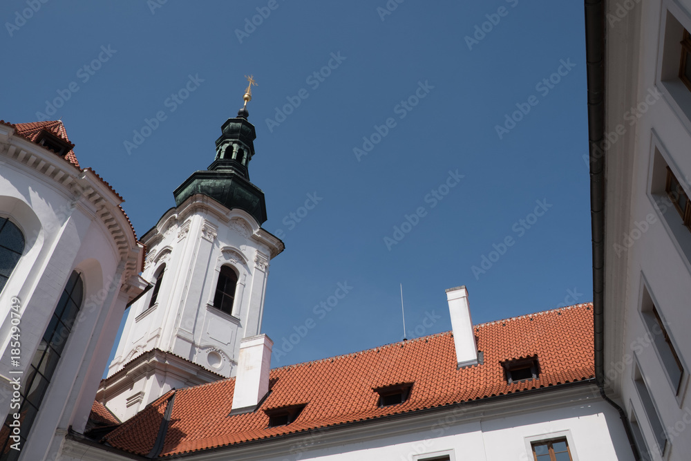 Looking up at the belfry of the Nanebevzeti Panny Marie Na Strahove (Basilica of the Assumption of the Virgin Mary) in Prague, Czech Republic on a sunny day, blue sky no clouds.
