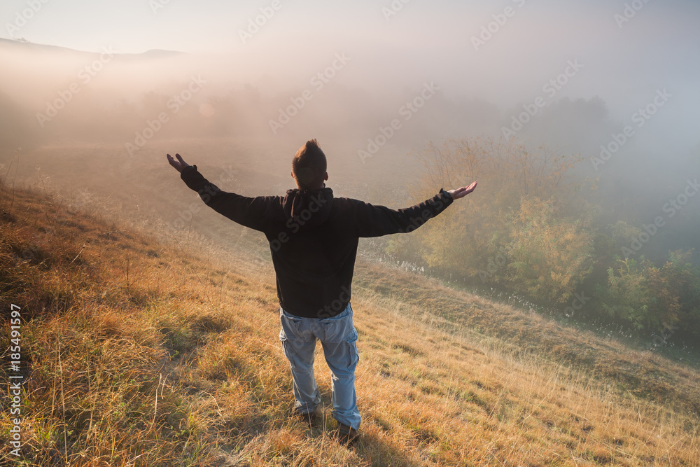 Man is hiking and enjoying sunrise in mountain. 
