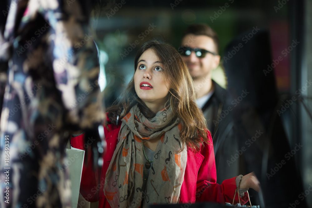 Young woman in shopping looking at her perfect dress
