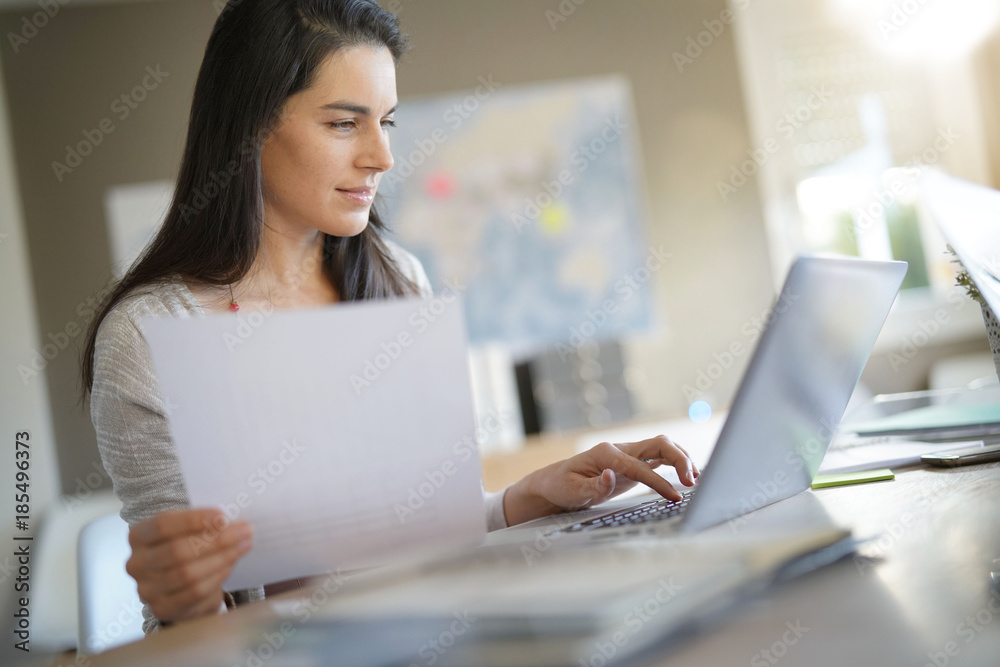 Businesswoman in office working on laptop Businesswoman in office working on laptop